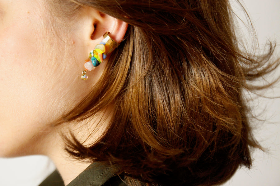 Woman wearing a one of a kind handmade turquoise and pink ear cuff by Gré with crystals, citrine, brass, aventurine